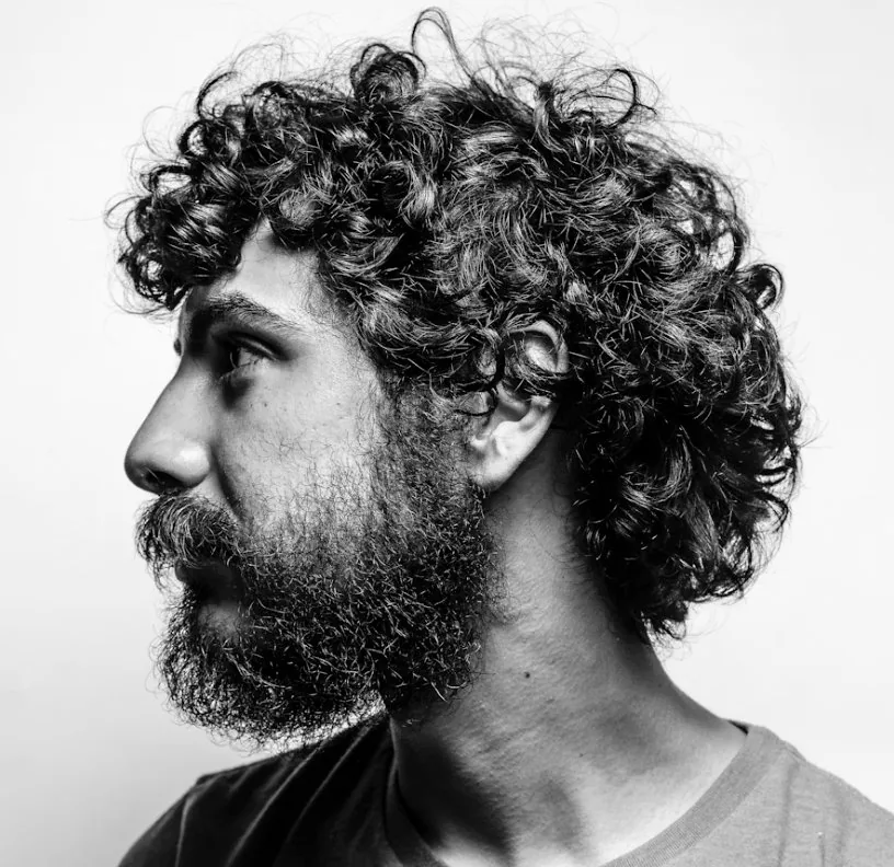 Curly hair care for men, shown in side profile with a healthy scalp