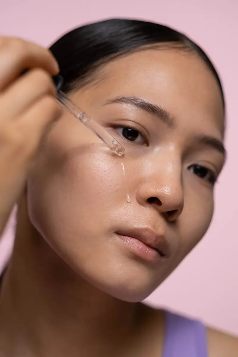 hydrating serum applied with a dropper to dewy, healthy skin showing urea's moisturising effect