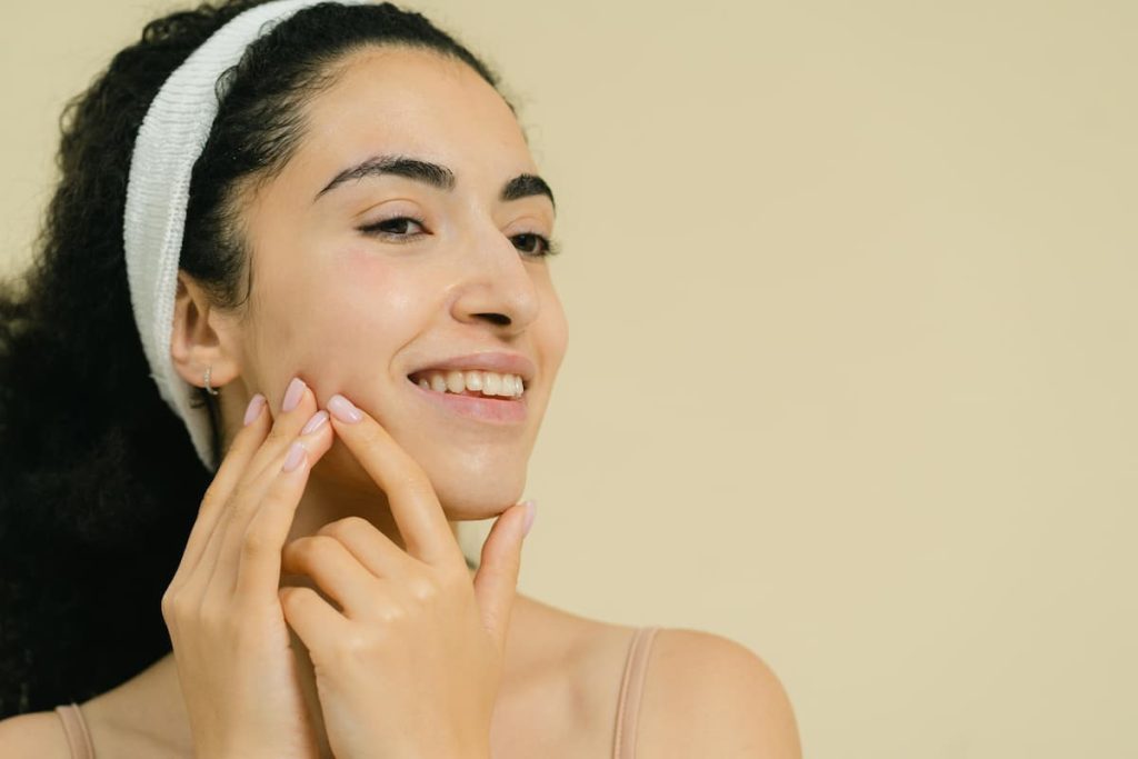 Woman with clear skin smiling after following an acne prevention routine