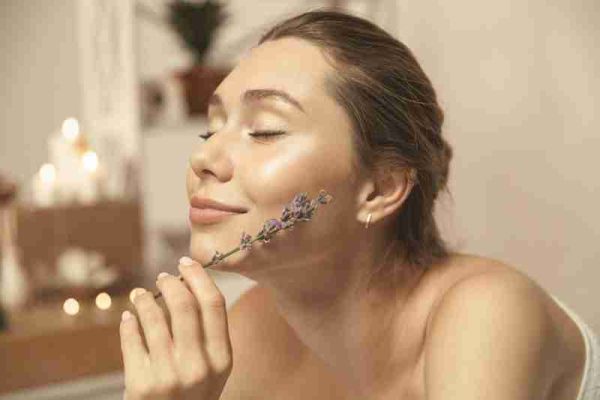 Woman relaxing with lavender, illustrating calming ingredients for sensitive skin